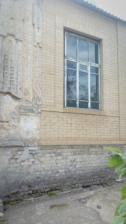 Окно на стене старого одноэтажного здания начала ХХ века